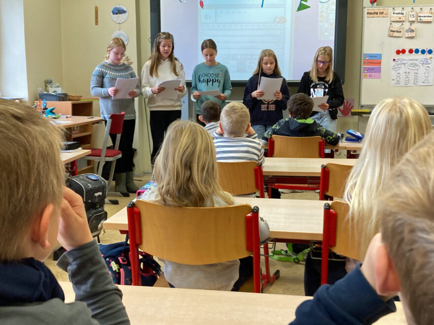 Kinder der 1a hören vorlesenden Kindern der 6. Klassen zu